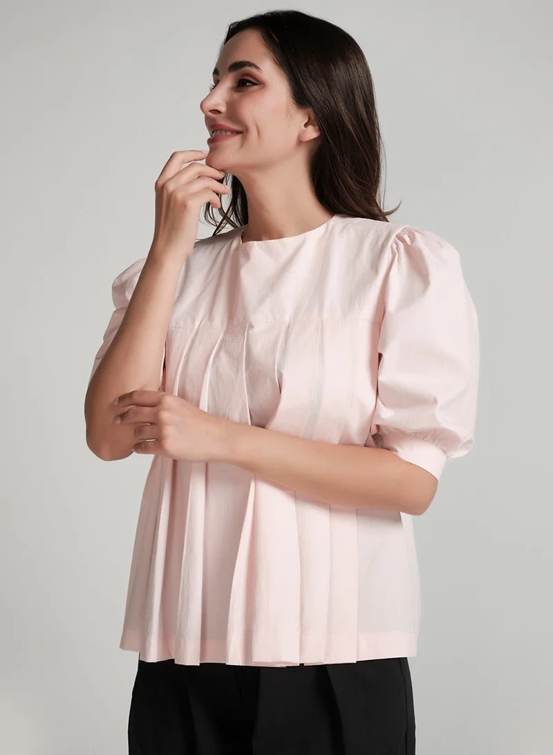 زجزاج قميص قطني وردي بأكمام قصيرة مطوية.